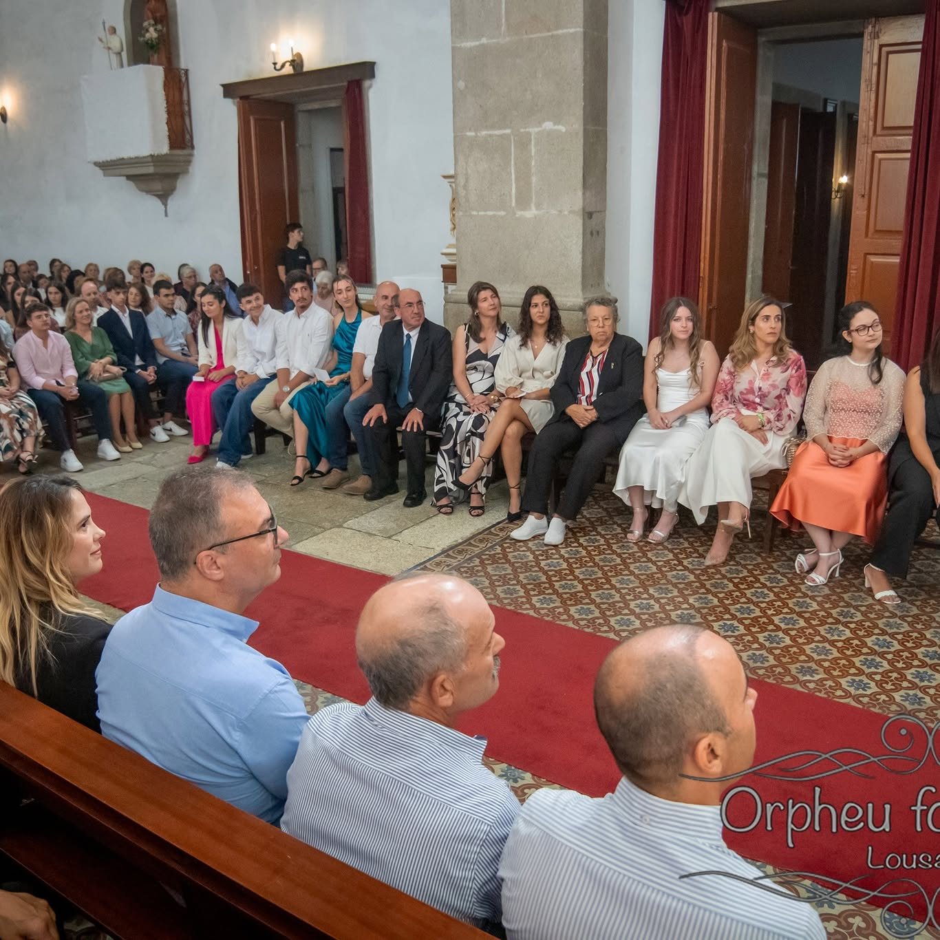 Assembleia sentada nos bancos da igreja durante a celebração